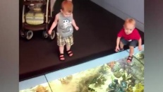 Deux petits bonshommes confus devant un plancher de verre  