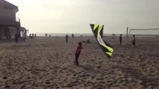 Ce maître du vent amuse les touristes sur la plage avec son cerf-volantt